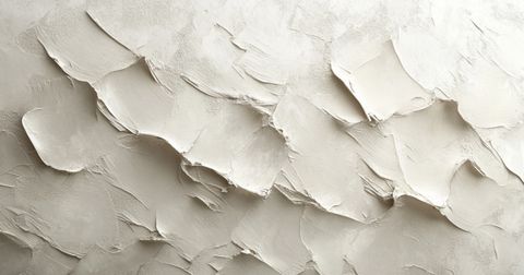 A close-up of a textured Venetian plaster surface in neutral beige, featuring dynamic, layered strokes that create depth and a rustic, artistic finish.